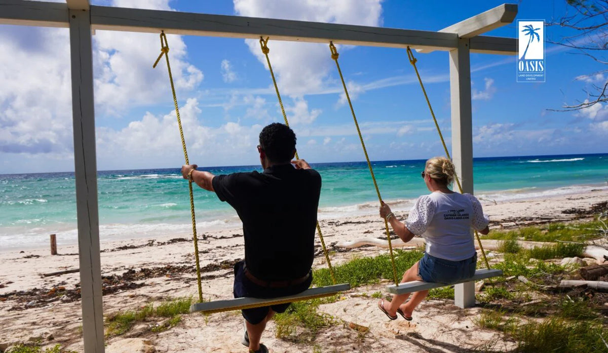 Enjoying the relaxed island lifestyle on a beach swing in Cayman Brac, close to available land for sale.